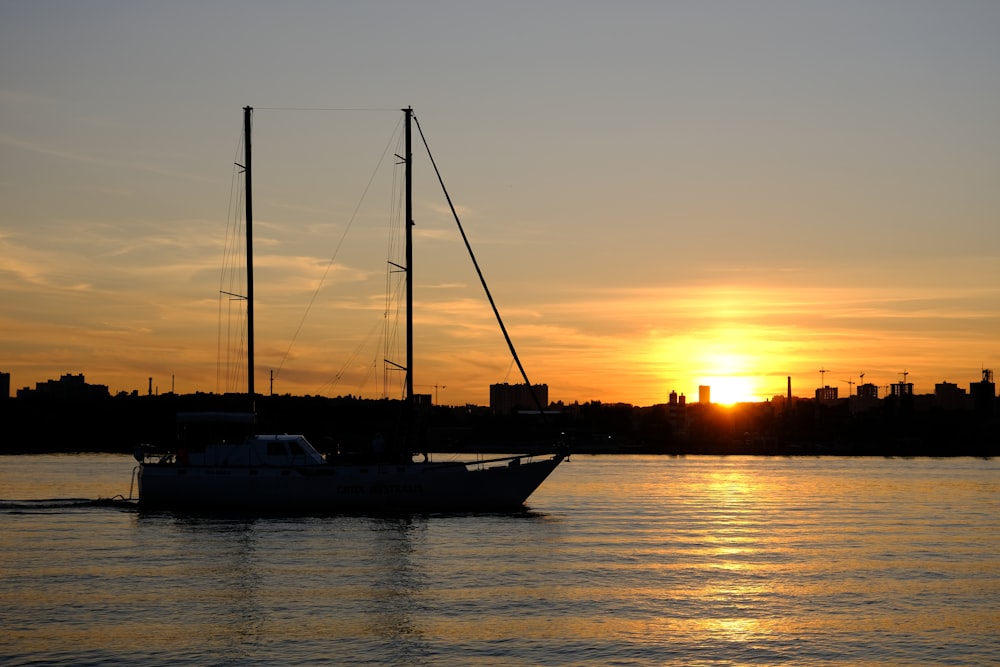 a sailboat in a body of water at sunset