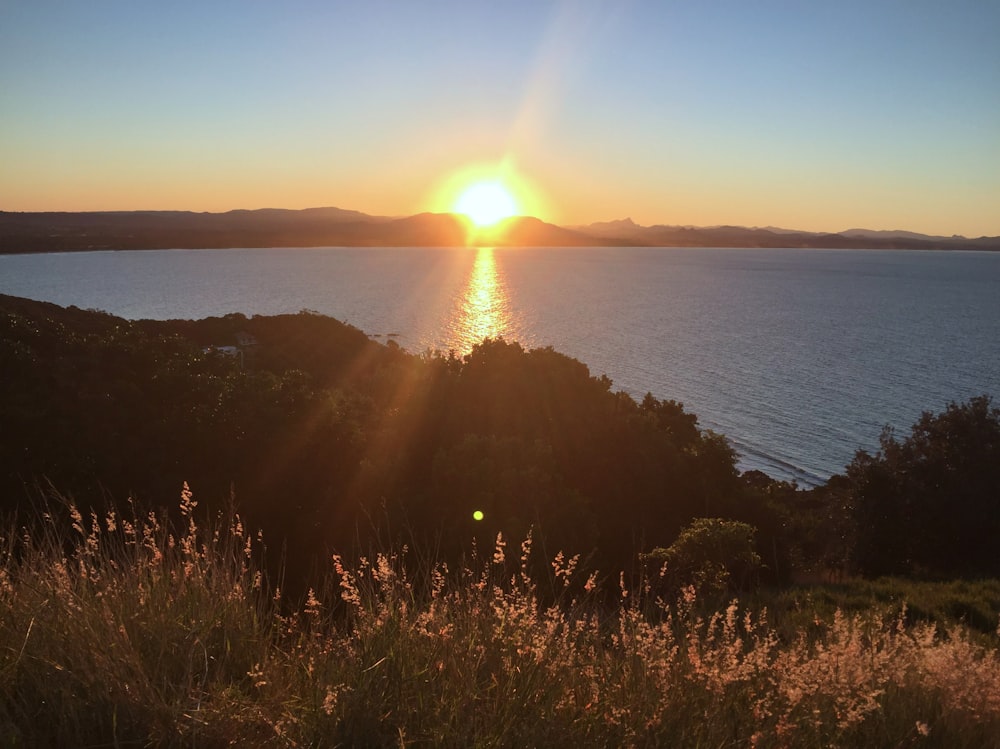 the sun is setting over a body of water