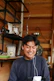 Close-up of a person smiling while wearing sleek Kyrot earplugs in a cozy home setting.