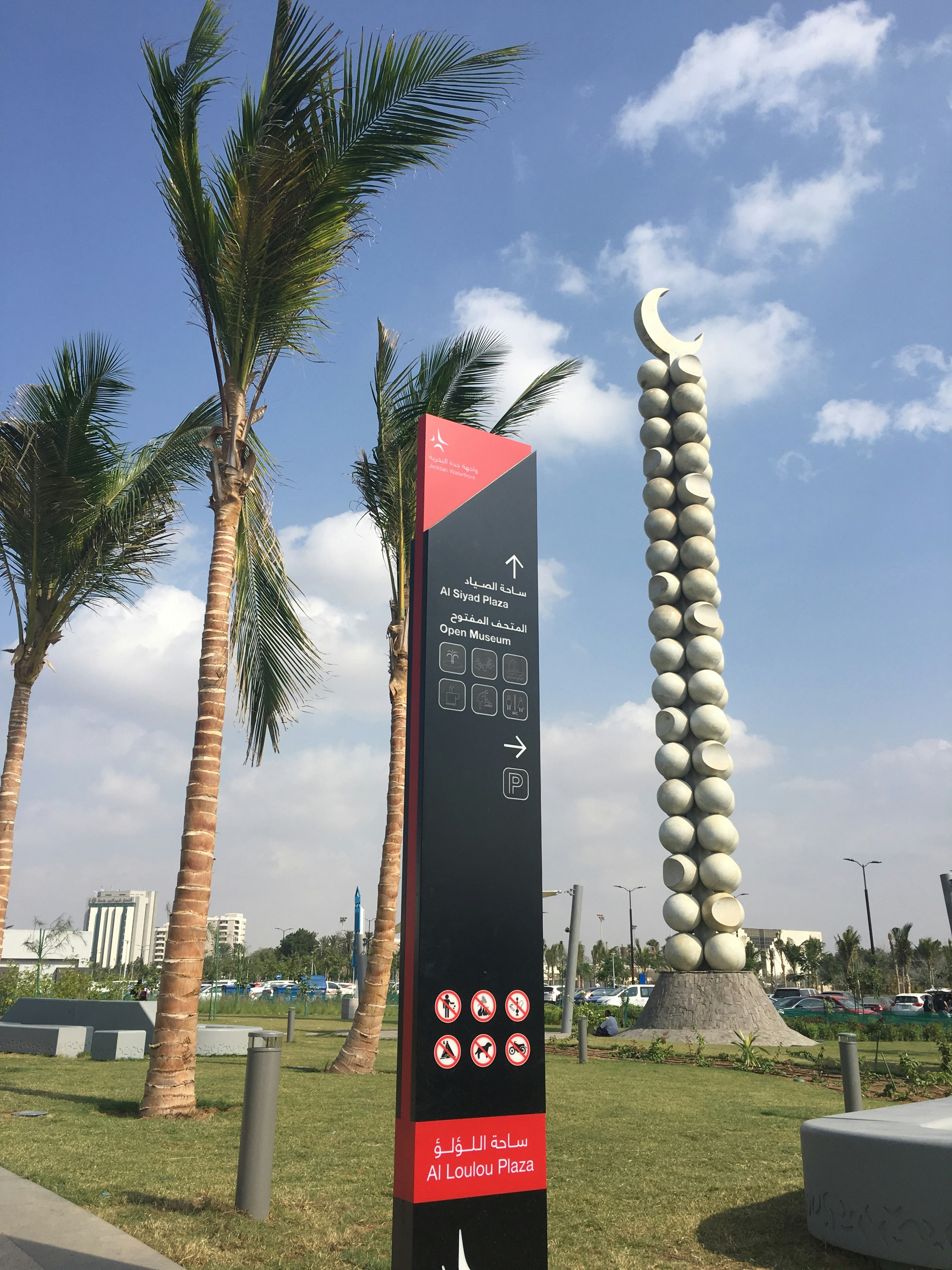 a sign in front of some palm trees