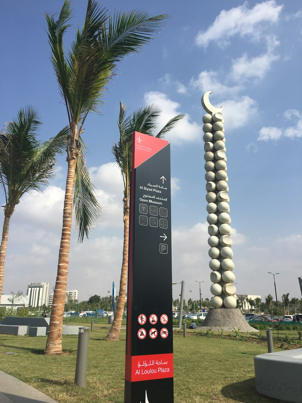 a sign in front of some palm trees