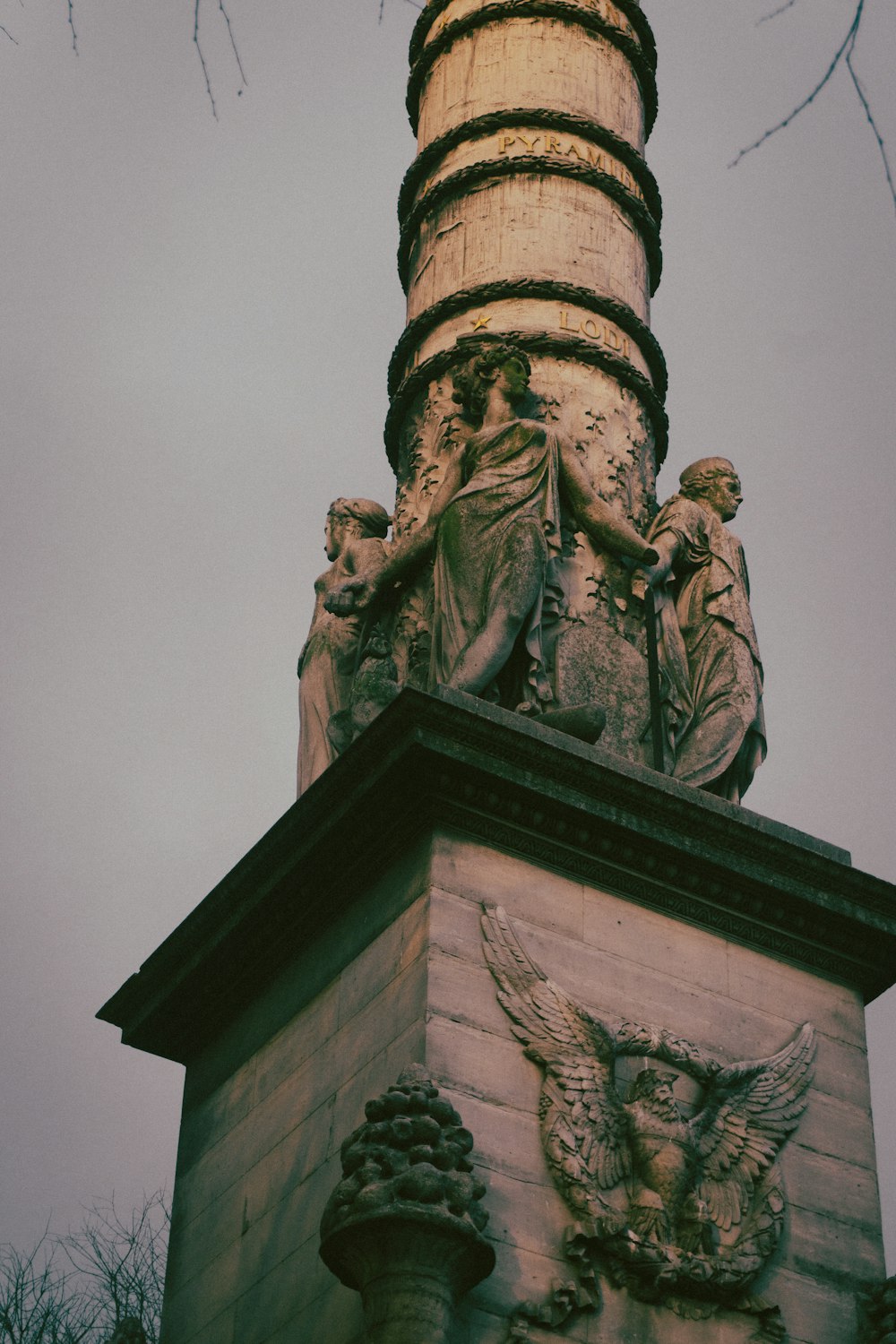 une statue au sommet d’une tour avec un fond de ciel