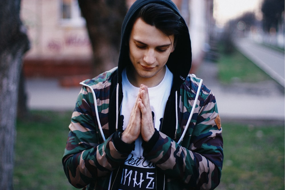 a man in a camouflage jacket is praying