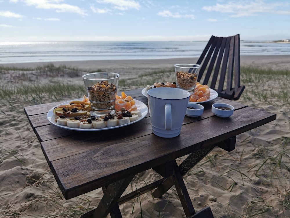 a wooden table topped with plates of food