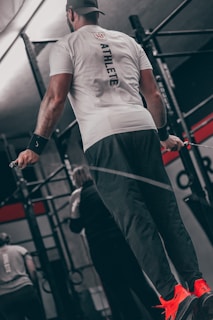 a man standing on a bar in a gym