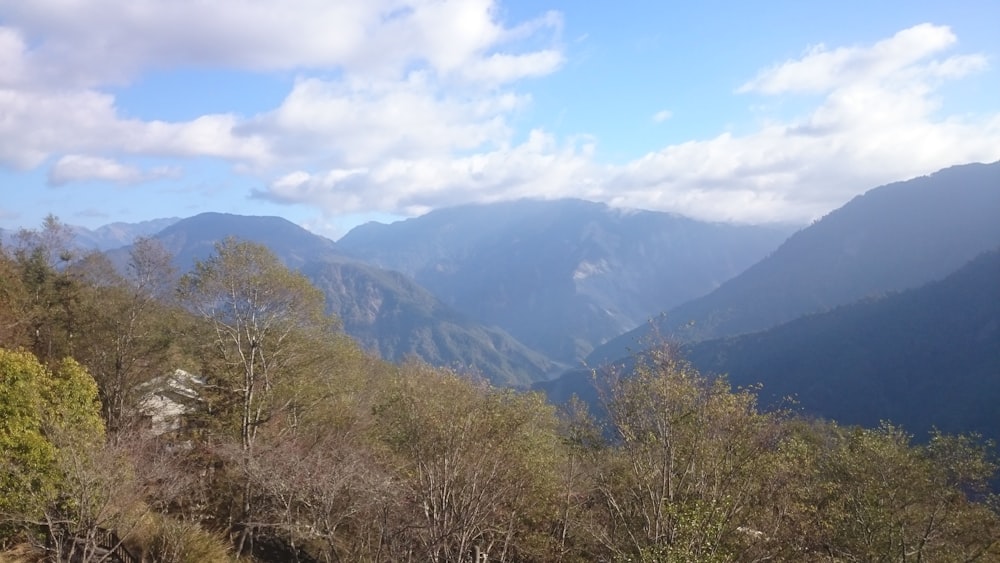 a view of a mountain range with trees and mountains in the background