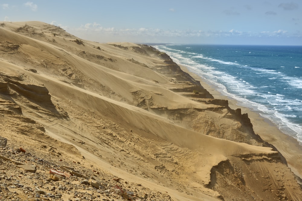 a long line of sand dunes next to the ocean