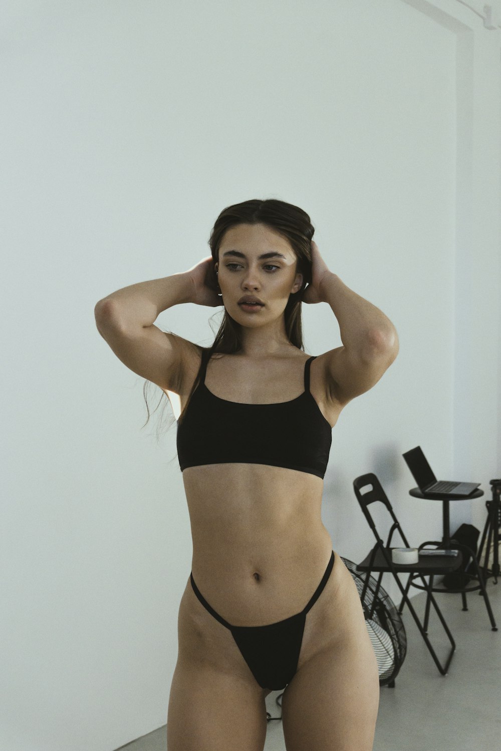 a woman in a black bikini standing in a room