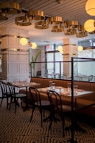 A high-end restaurant interior with circular skylight diffusers integrated into a stretch ceiling.