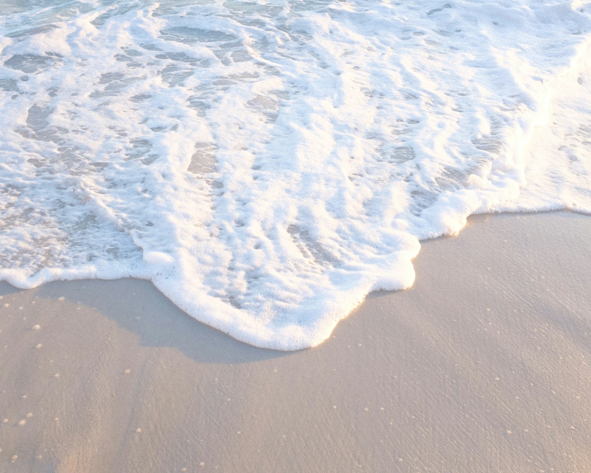 a beach with a wave coming in to the shore