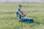 a man sitting in a chair in a field