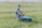 a man sitting in a chair in a field