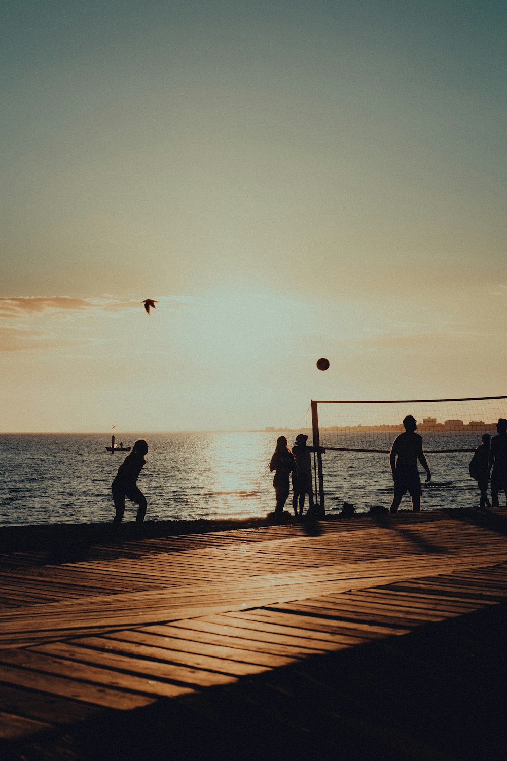 Un grupo de personas jugando voleibol en un muelle