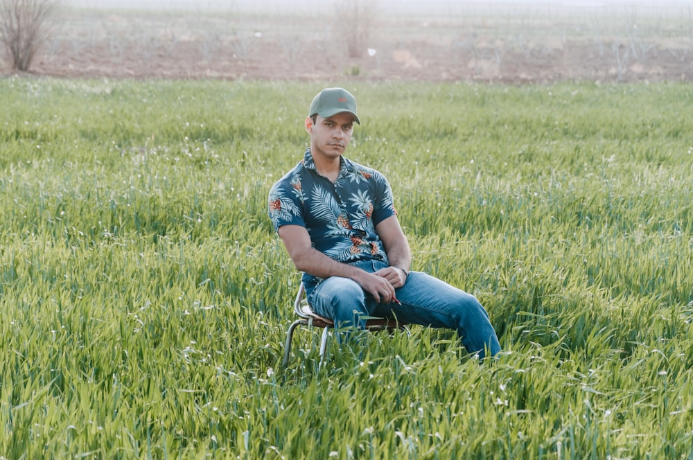 a man sitting on a chair in a field