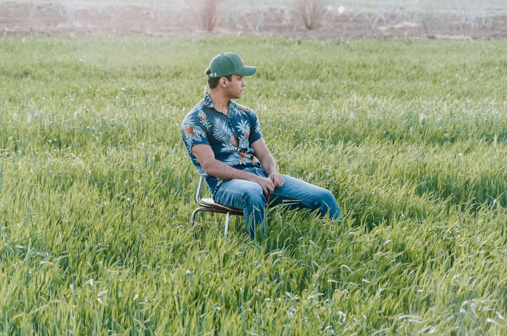 a man sitting in a chair in a field