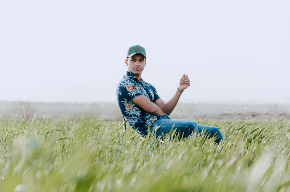 a man sitting in a field of tall grass