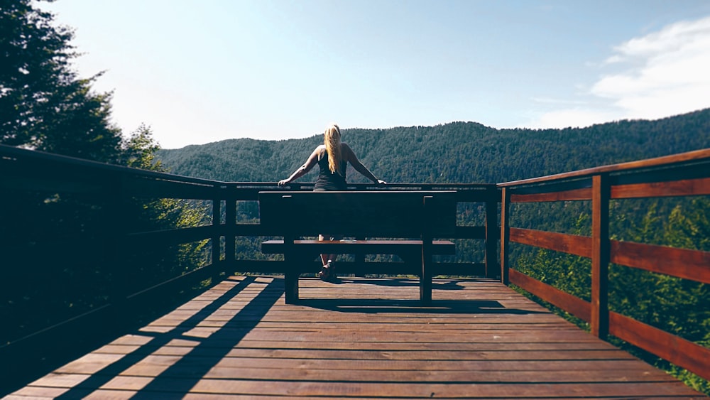 a person sitting on a bench on a bridge