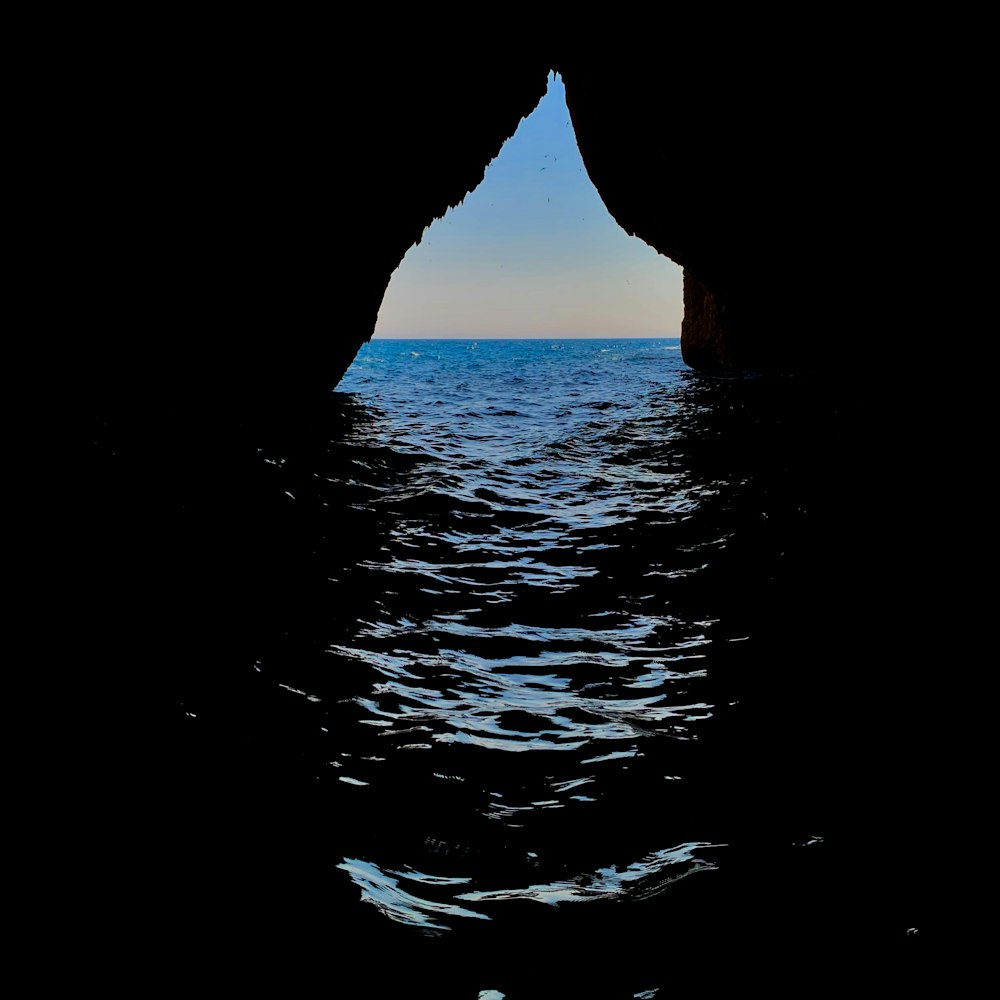a large body of water with a small cave in the middle of it
