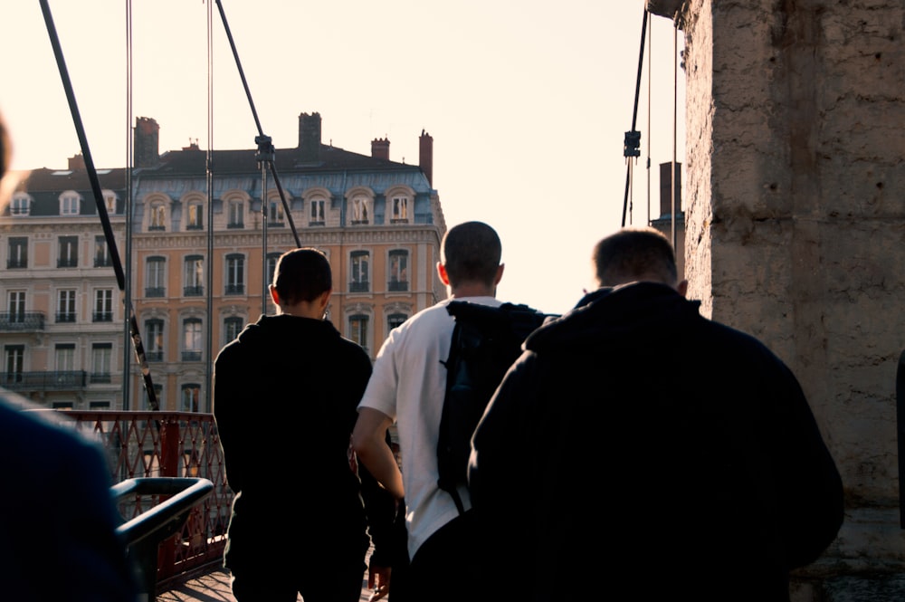 a group of men walking across a bridge