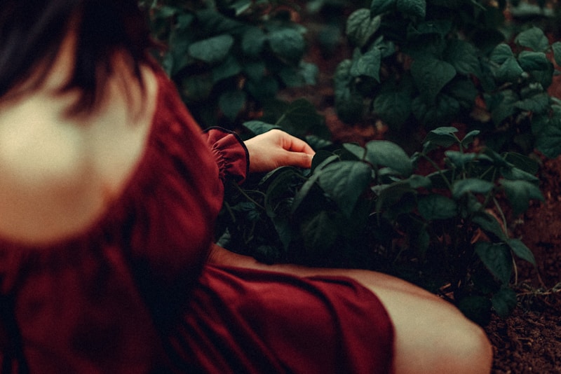 a woman in a red dress sitting on the ground