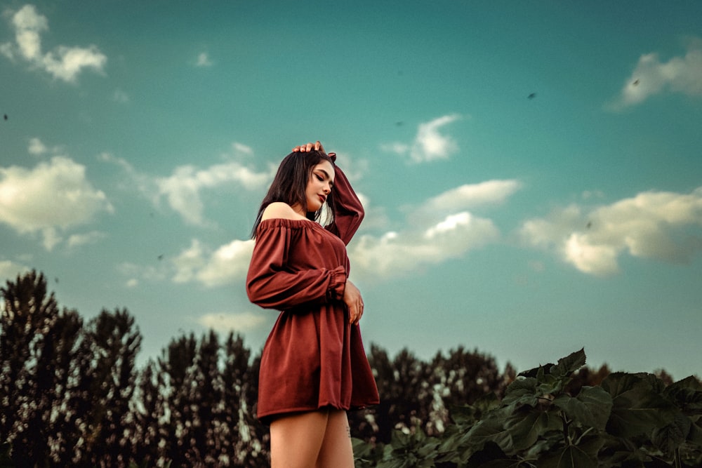 a woman in a red dress standing in a field