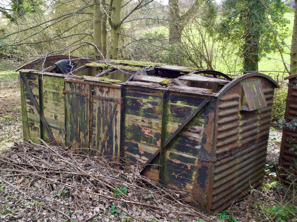 Ein alter verrosteter Müllcontainer im Wald