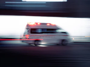 an ambulance is driving down the street with its lights on
