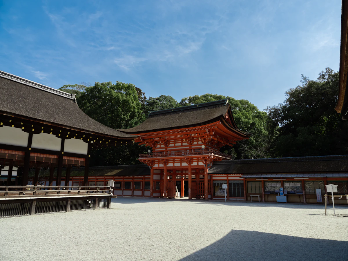 A traditional wooden shrine hall at Shimogamo Jinja set beside the ancient trees of Tadasu-no-Mori forest, Kyoto