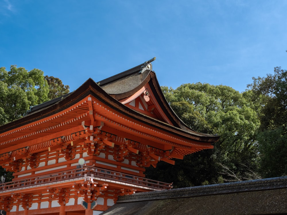 a tall red building sitting next to a forest