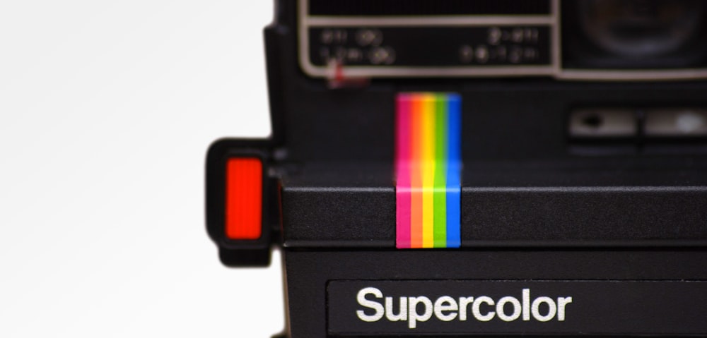 a polaroid camera with a rainbow strip on it