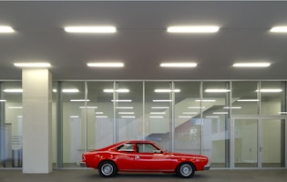 a red car parked in front of a building