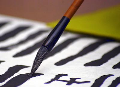 Close-up of elegant calligraphy brush strokes on white paper, symbolizing clarity.