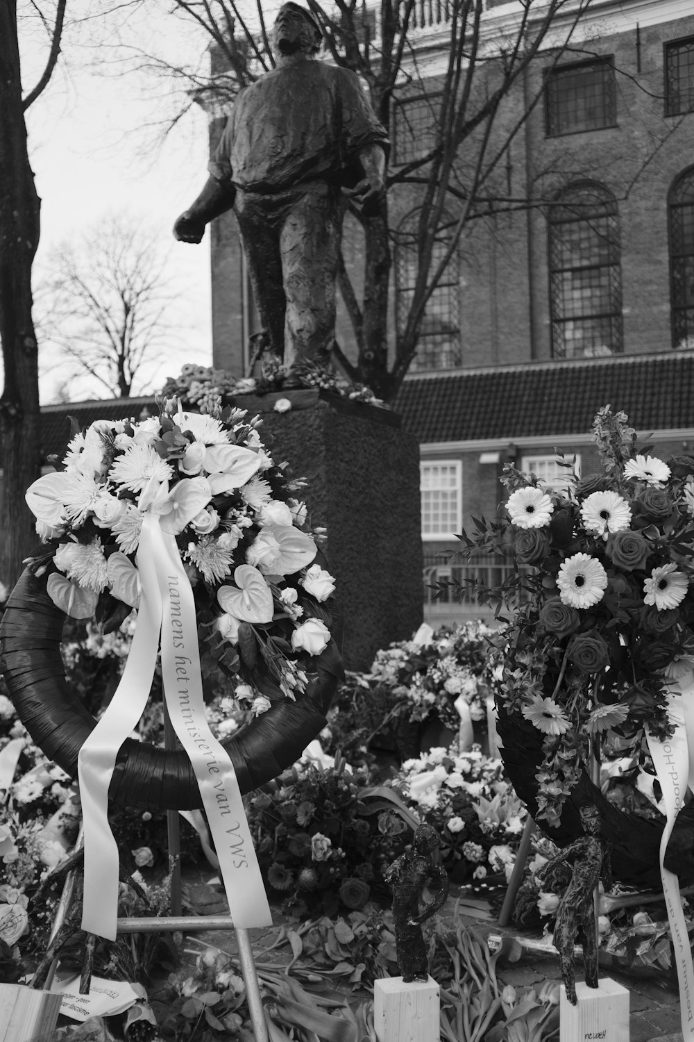 a black and white photo of flowers and a statue