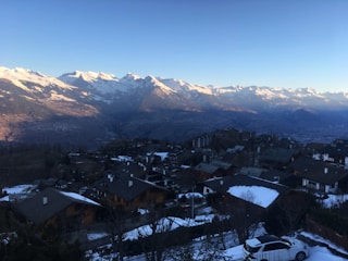 A scenic view of a ski resort with a stylish vehicle in the foreground.