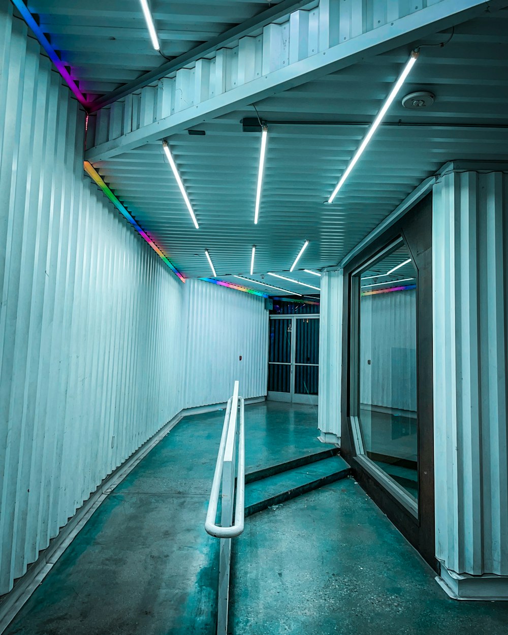 a long hallway with white walls and lights