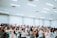 A diverse group of people gathered in a bright church sanctuary during worship.
