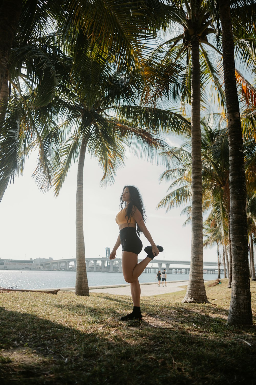 a woman in a bathing suit standing under palm trees