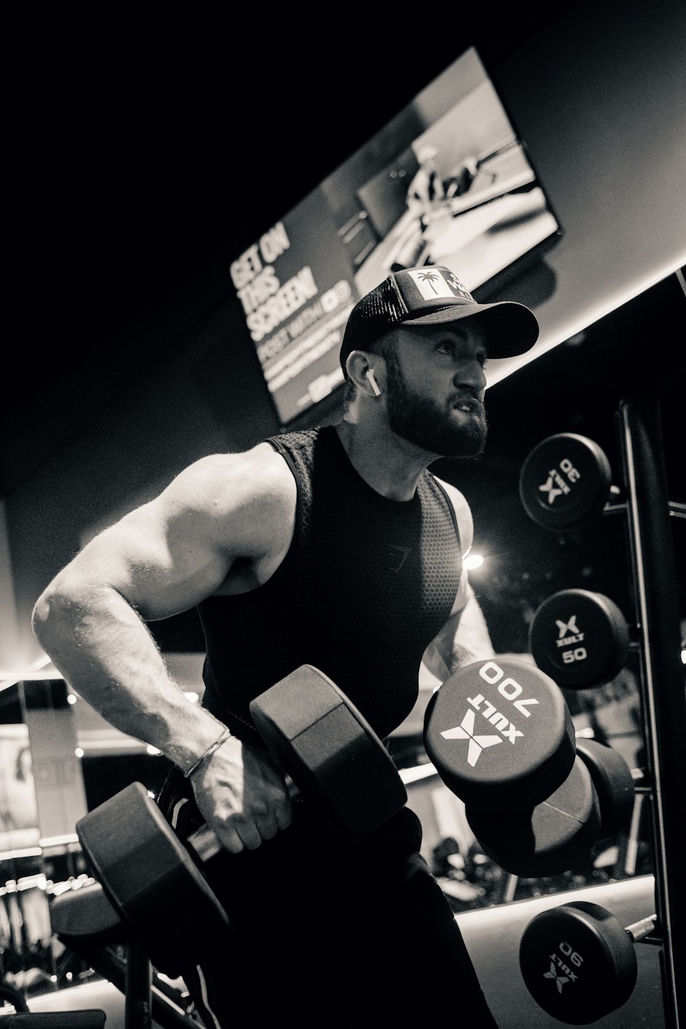 a man holding a pair of dumbs in a gym