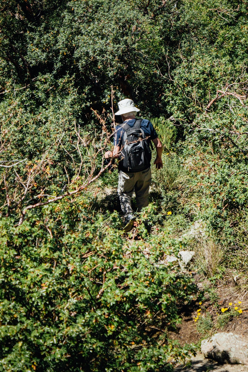 a man with a backpack hiking up a hill