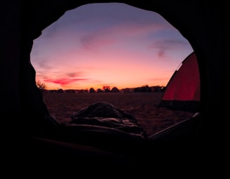 A sunset view with tents silhouetted against the colorful sky.