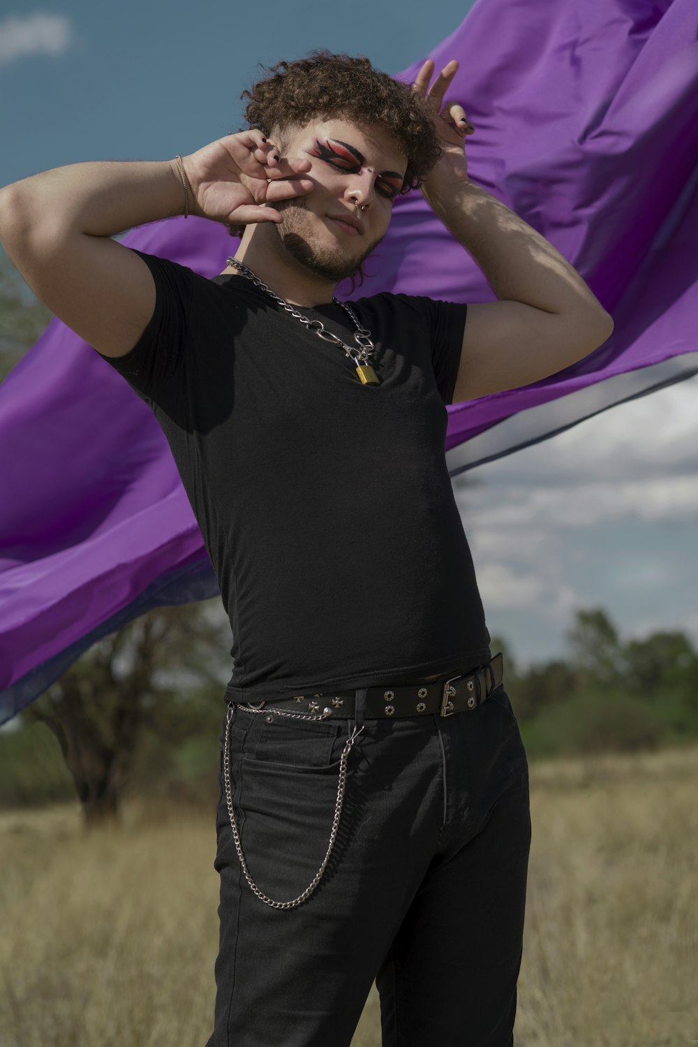 a man in a black shirt holding a purple scarf