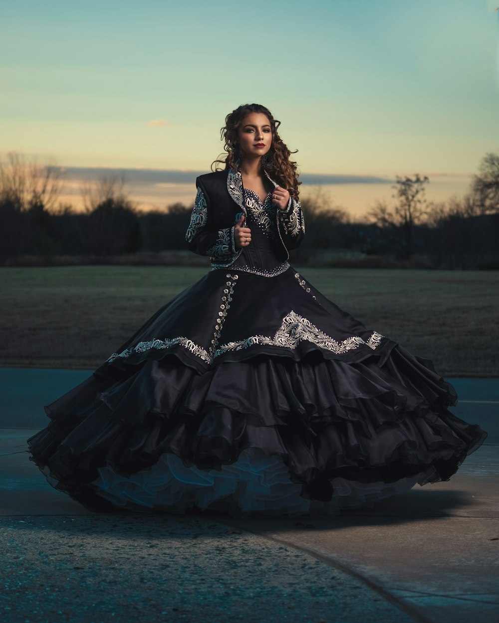 uma mulher em um vestido preto longo posando para uma foto