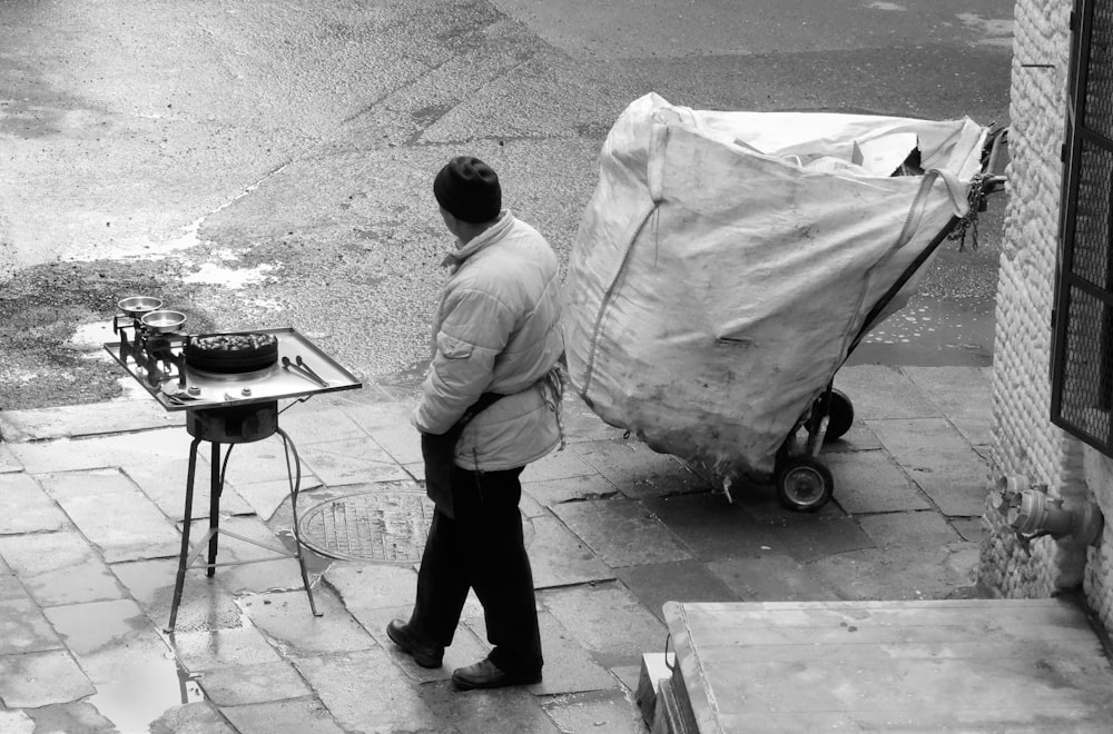 a man pushing a cart down a street