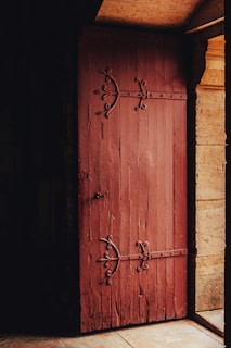 A rustic barn-style door with iron hinges, nestled in a cozy cottage entrance