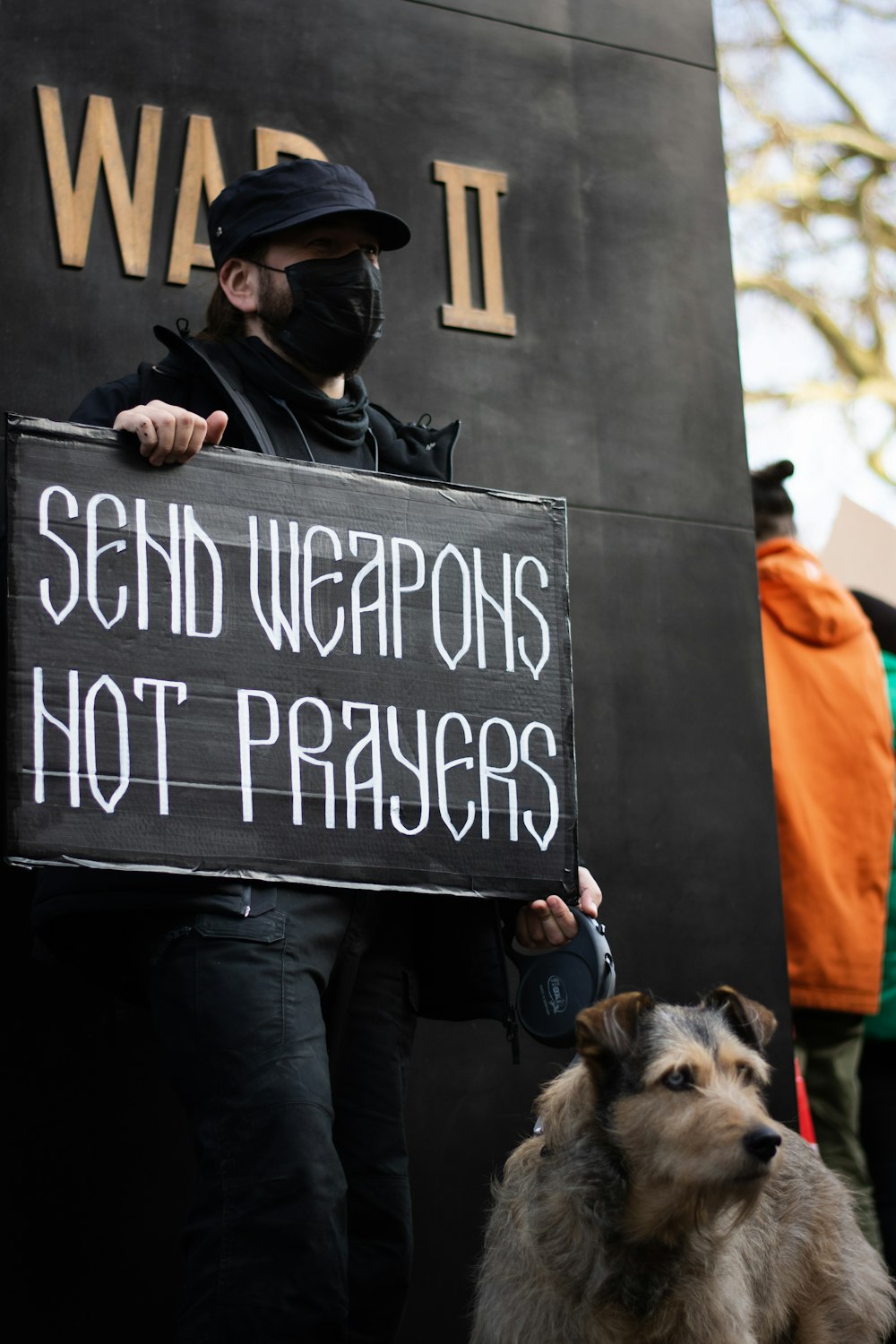 a man holding a sign with a dog in front of him