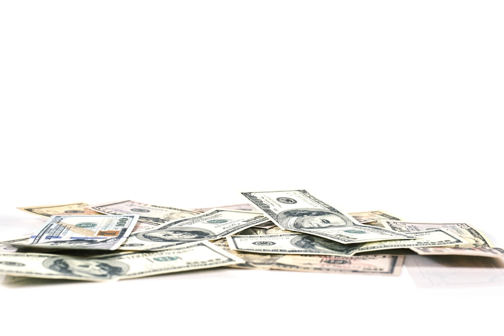 a pile of money sitting on top of a white table