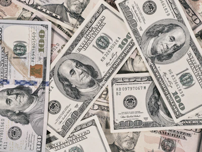 A scattered pile of American one hundred dollar banknotes