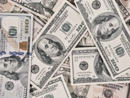 A scattered pile of American one hundred dollar banknotes