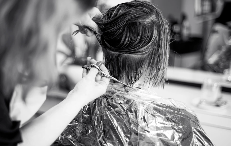Une coiffeuse réalise une coupe sur une cliente