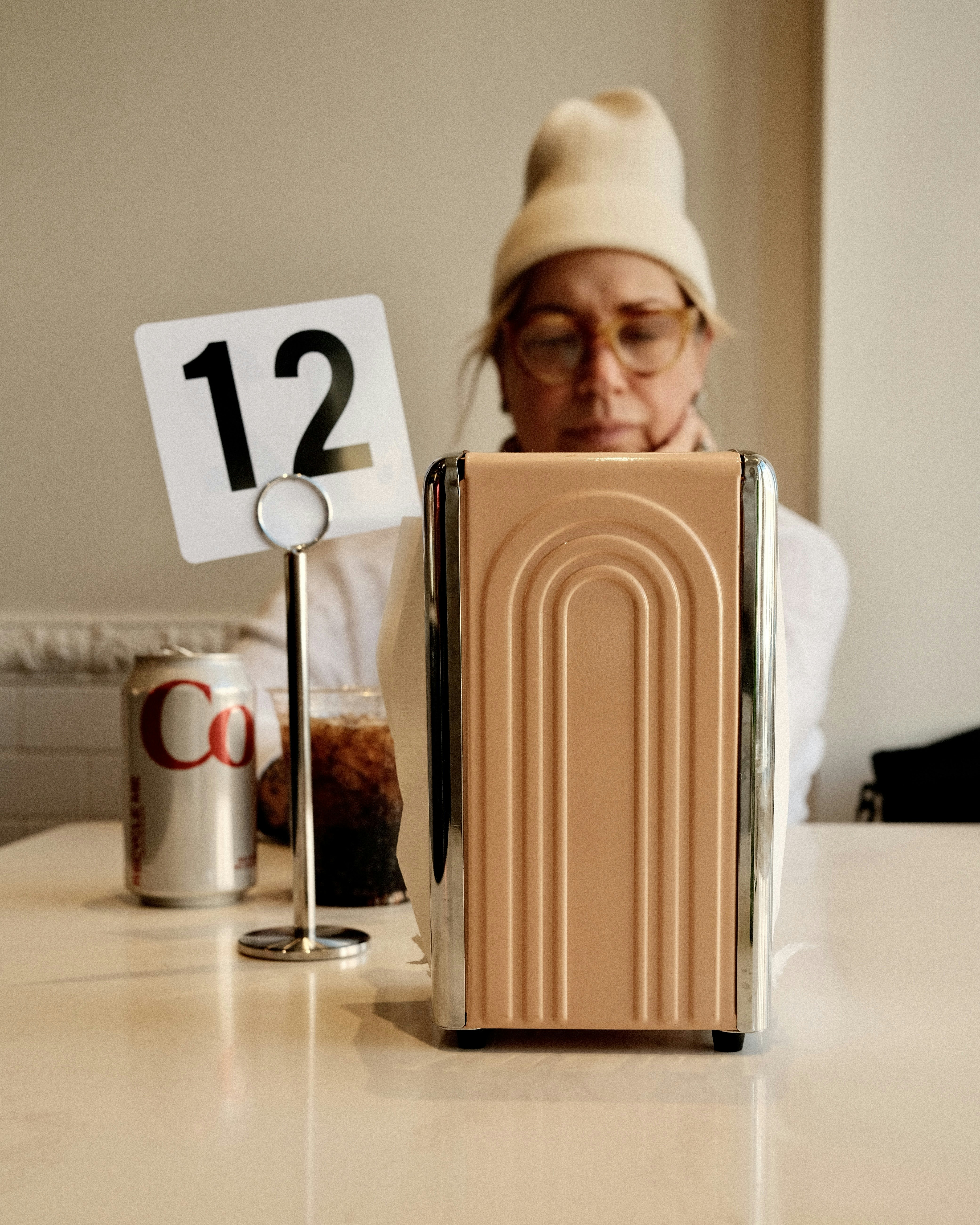 a woman sitting at a table in front of a suitcase